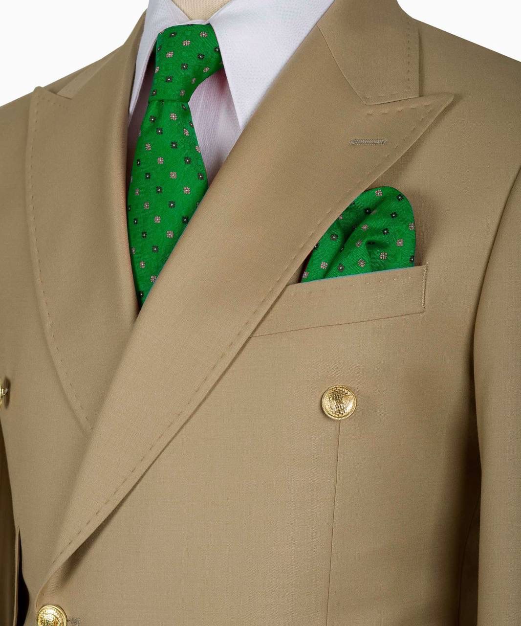 Beige suit jacket with a green patterned tie and pocket square on a white background