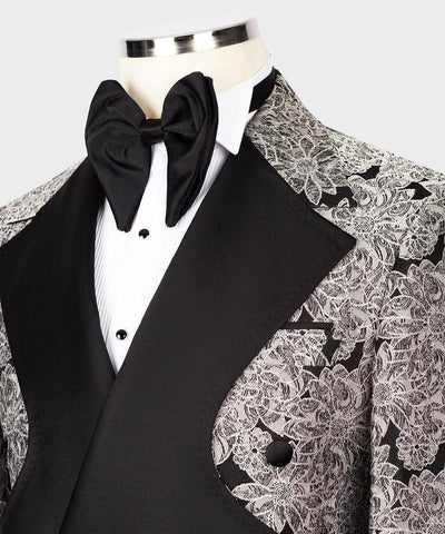 Black tuxedo with white lace detailing on a mannequin against a white background