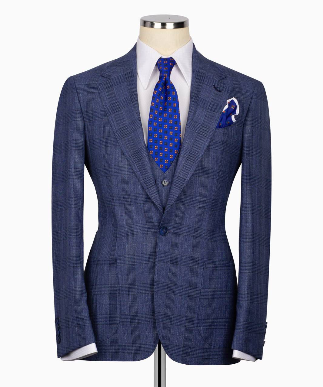 Blue checkered suit jacket on a mannequin with a white shirt and blue tie.