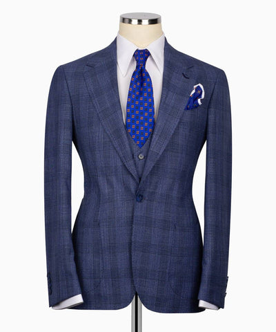 Blue checkered suit jacket on a mannequin with a white shirt and blue tie.