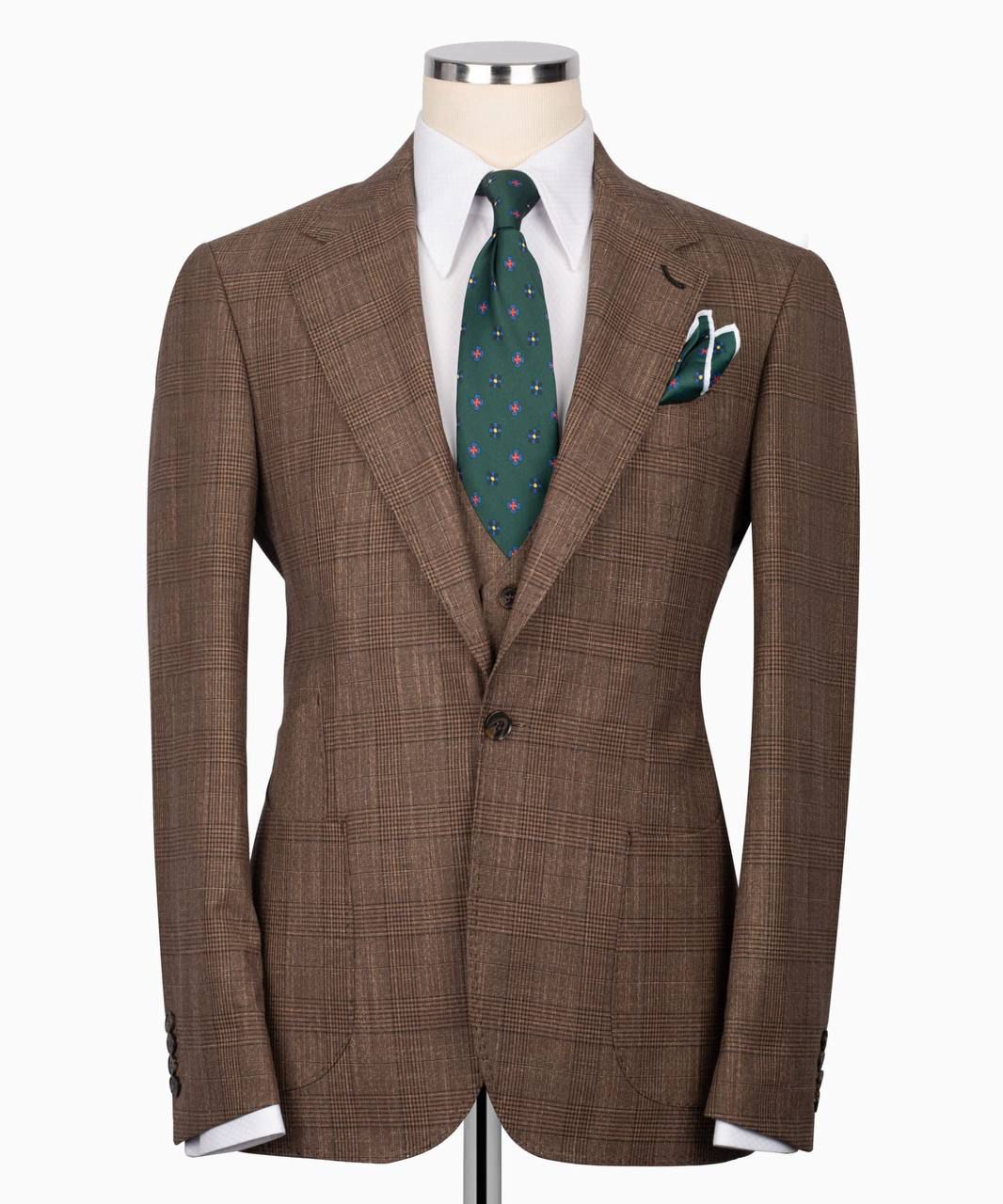 Brown checkered suit on a mannequin with a white shirt, green tie, and pocket square.