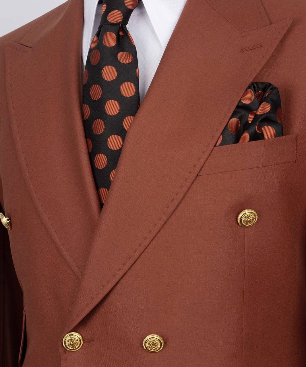 Brown suit jacket with a polka dot tie and pocket square.