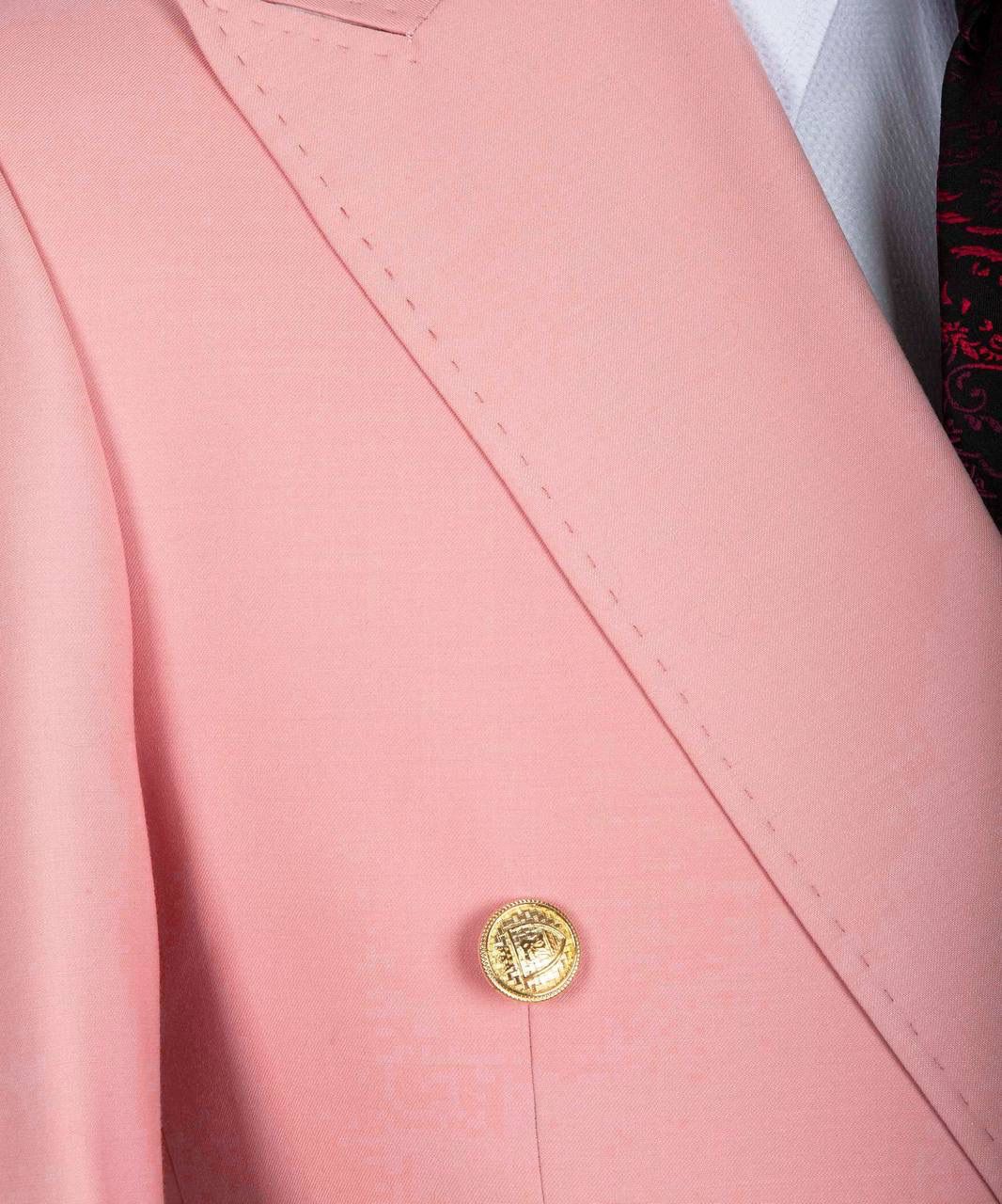 Close-up of a pink blazer with a gold button.